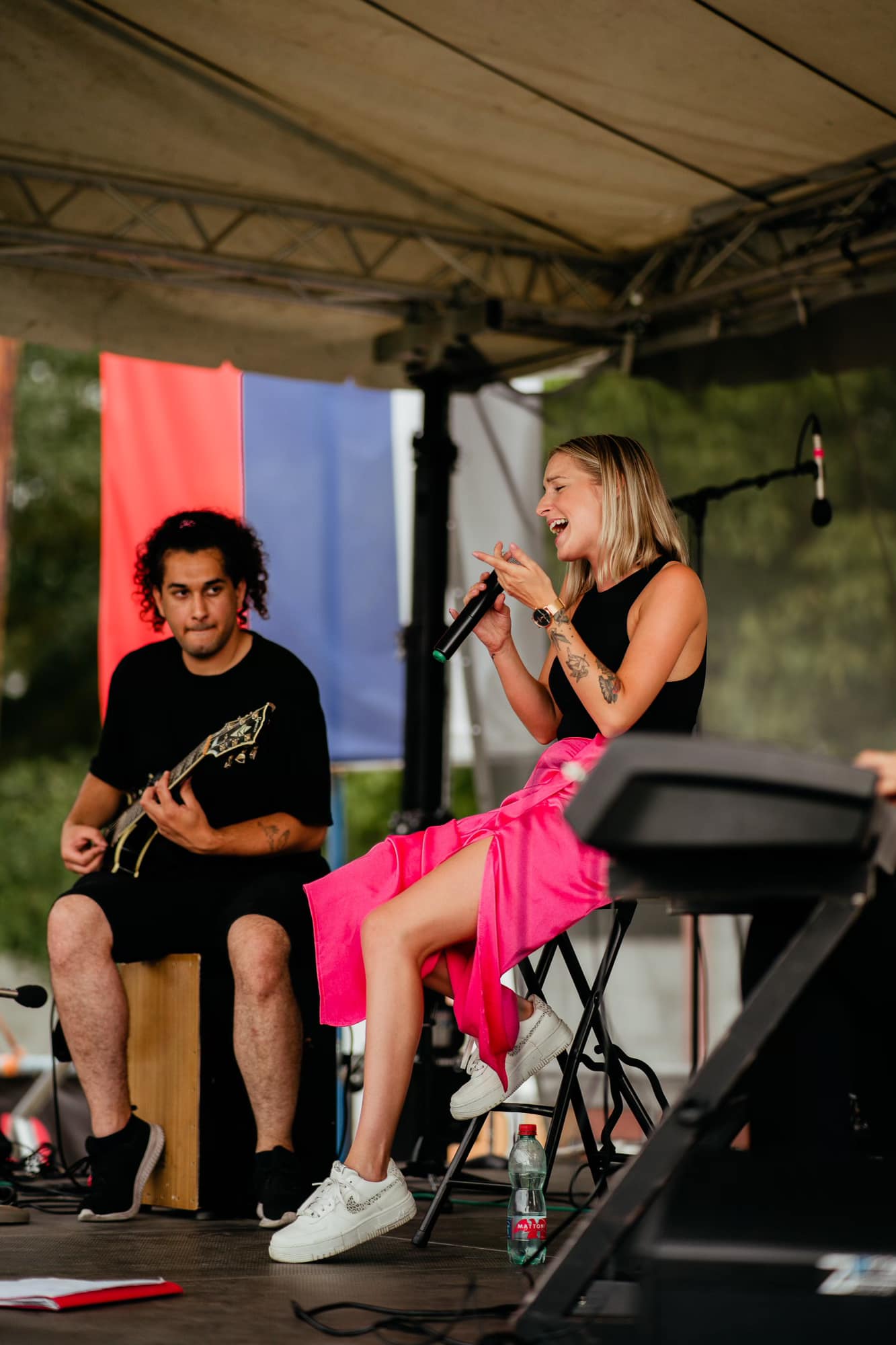 Lenka Piešová spievajúca vonku na pódiu v ružovej sukni