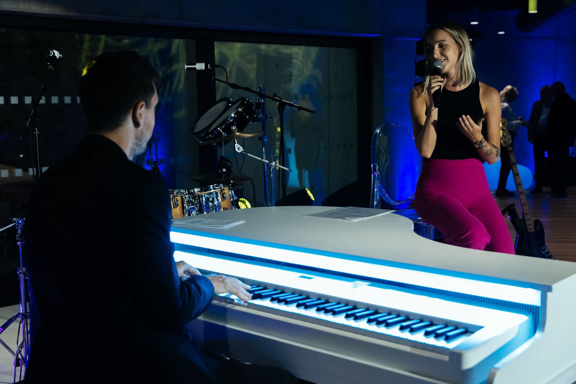 Lenka Piešová sediaca pri klaviristovi spieva v jeho doprovode